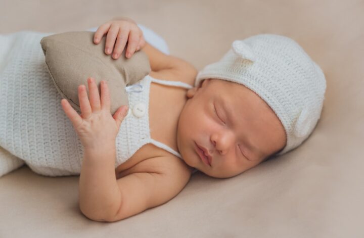niemowlak w cienkiej czapeczce śpi